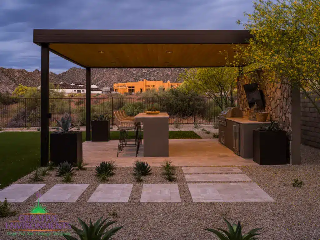 Custom backyard design with paver steps, metal shade structure and outdoor bar seating.