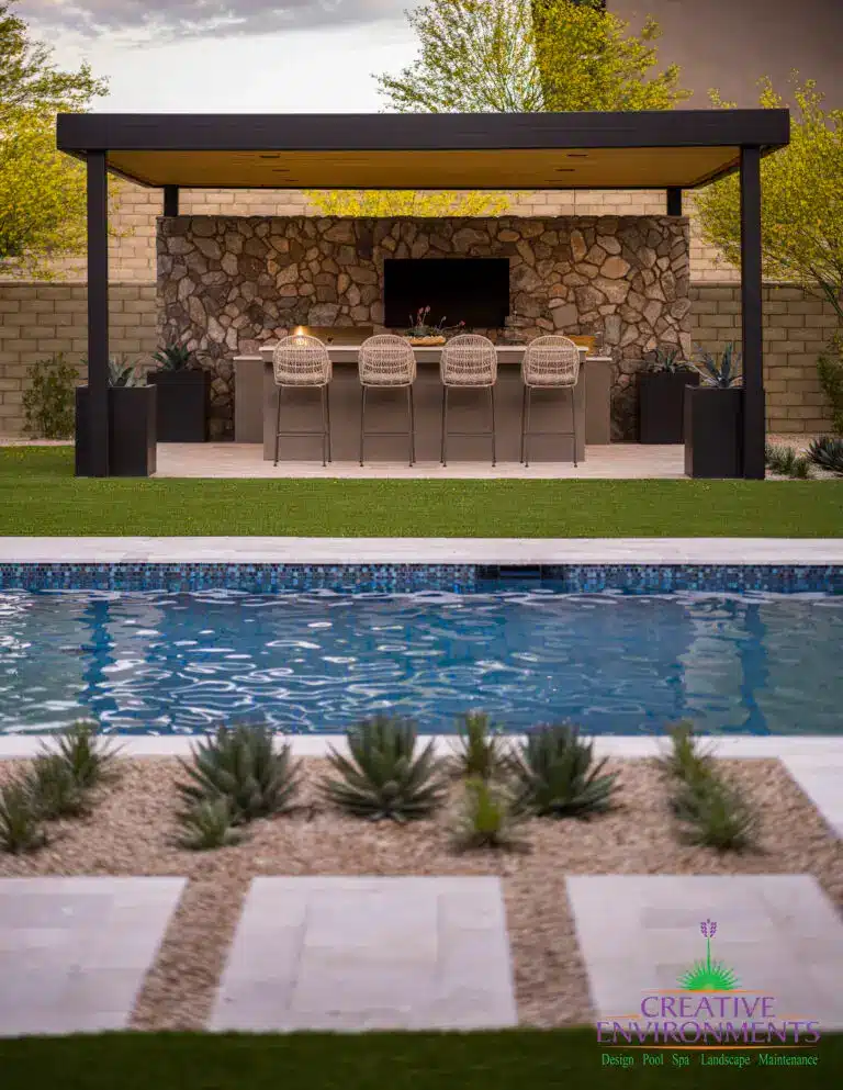 Custom backyard design with blue pool, angled shade structure and large metal planters.