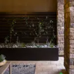 Custom backyard design with living wall, natural stone columns and outdoor seating area.