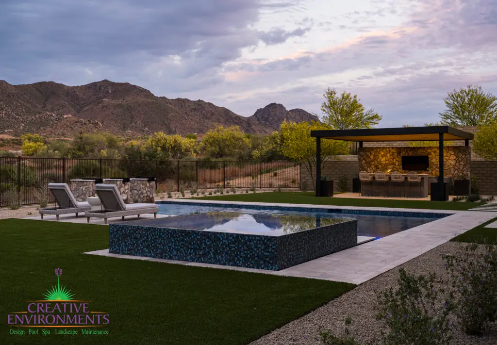 Custom backyard design with custom metal shade structure, blue spa and multiple seating areas.