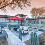 Custom backyard design with cacti, large planters and multiple seating areas.