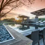 Custom backyard design with cantilevered shade structure, large planters and zero-edge pool.