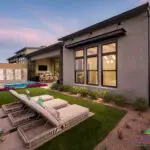Custom small backyard design with multiple seating areas, organized planting and artificial turf.