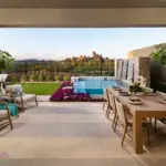 Custom backyard design with outdoor kitchen, acrylic spa with water feature and multiple seating areas.