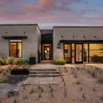 Custom front yard design with organized planting, brick pavers and metal planters.