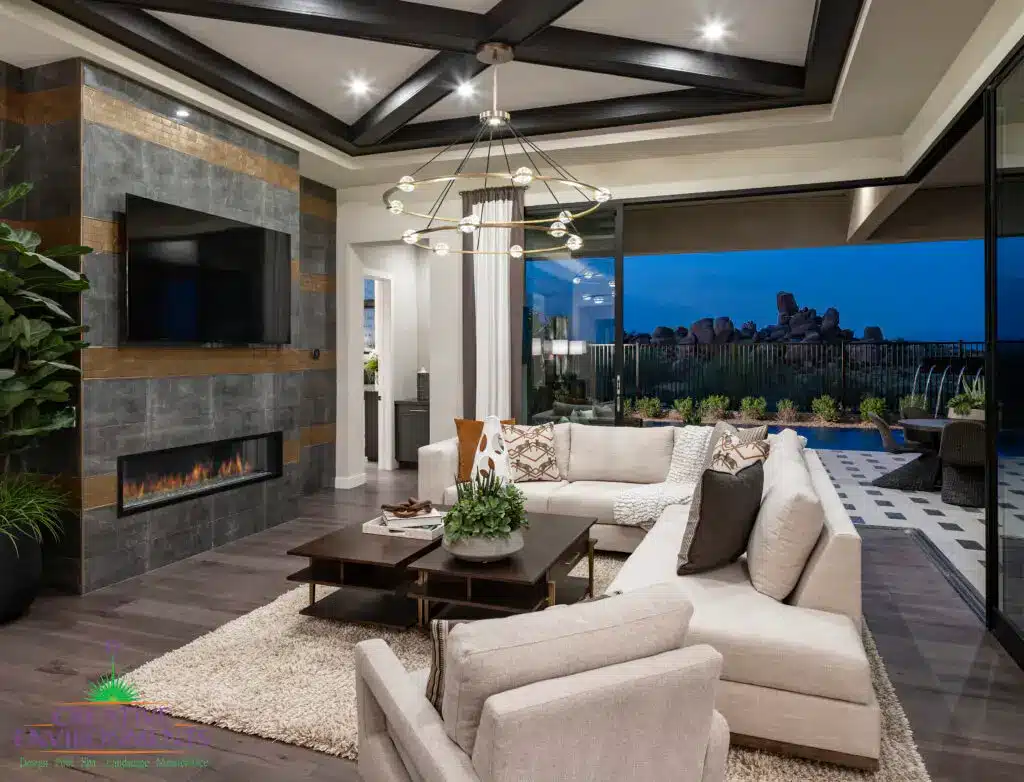 Custom seamless indoor/outdoor living experience with metal fencing, chandelier and metal scupper water feature into pool.
