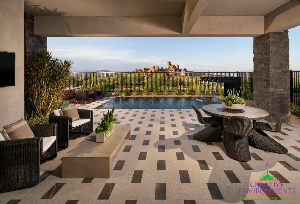 Custom backyard design with multiple seating areas, metal scupper water feature and metal fencing.