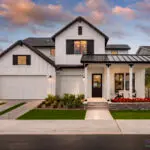 Custom front yard design with organized planting, mixed material driveway and annuals.