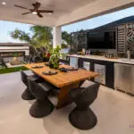 Custom backyard design with metal statement piece, outdoor bar and recessed lighting.