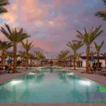 Custom community clubhouse with large community pool, multiple seating areas and pool lighitng.