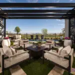 Custom backyard design with metal statement piece, patterned artificial turf and large planters.
