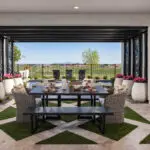 Custom backyard design with metal statement piece, artificial turf pattern and large planters.