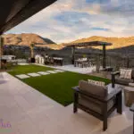 Custom backyard design with multiple seating areas, recessed lighting and artificial turf