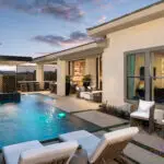 Custom backyard design with zero-edge pool, multiple seating areas and planters.