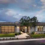 Custom front yard design with tree lighting, artificial turf and natural stone tile walkway.