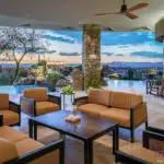 Backyard design with multiple seating areas and outdoor fan.