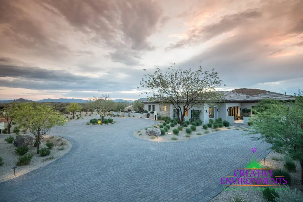 Custom front yard design with brick paver roundabout and desert planting.