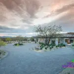 Custom front yard design with brick paver roundabout and desert planting.