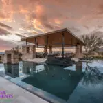 Custom backyard design with blue, lautner-edge pool and angled shade structure with outdoor kitchen.