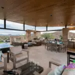 Custom backyard design with angled shade structure, multiple seating areas and outdoor kitchen.