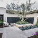 Cyustom fron yard design with large water wall and desert landscape.