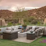 Custom backyard design with large potted plants, metal gate and fire pit.