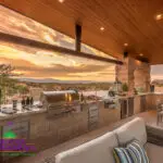 Custom backyard design with angled shade structure, recessed lighting and outdoor kitchen.