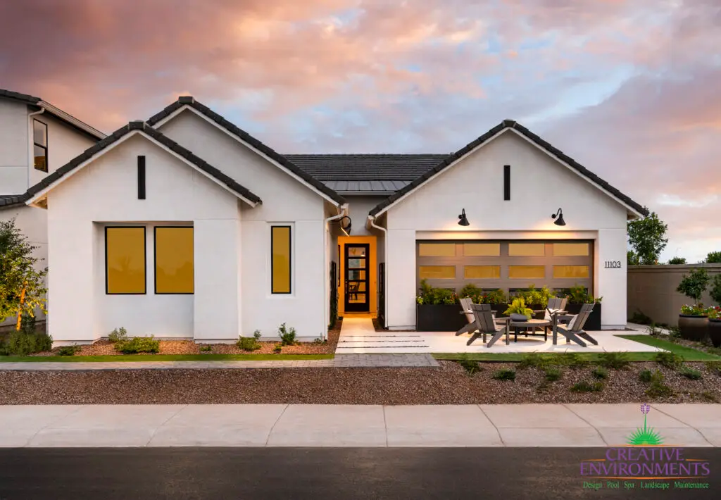 Custom front yard design with seating area and large potted plants.