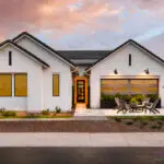 Custom front yard design with seating area and large potted plants.