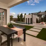 Custom backyard design with custom metal shade structure and privacy hedges.