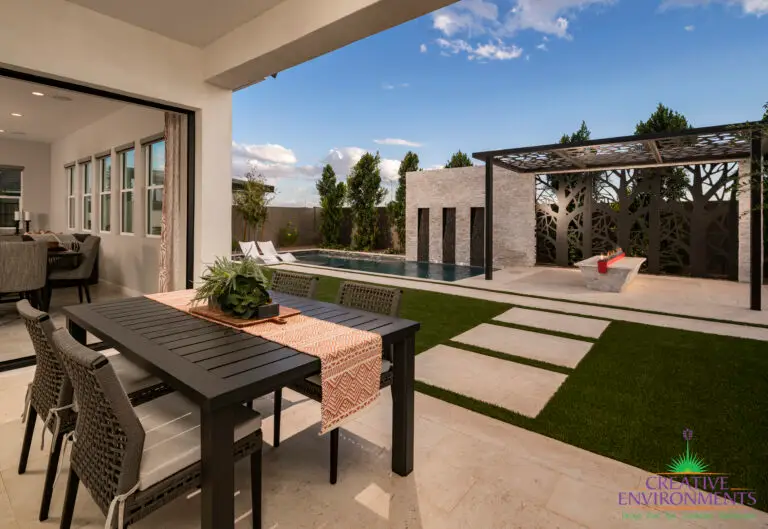 Custom backyard design with custom metal shade structure and privacy hedges.