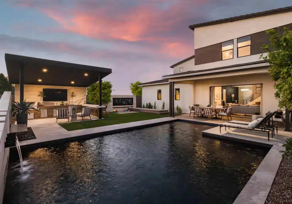 Backyard design with artificial turf, angled shade structure and metal planters.