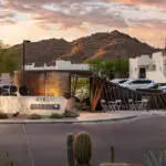 Custom community entrance with metal sign, unique metal statement piece and outdoor dining area.