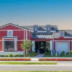 Custom front yard design with organized planting, annuals and farmhouse design.