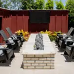 Custom backyard design with outdoor TV, linear fire pit and outdoor entertainment area.