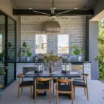 Custom backyard design with outdoor kitchen, outdoor seating areas and large planters.