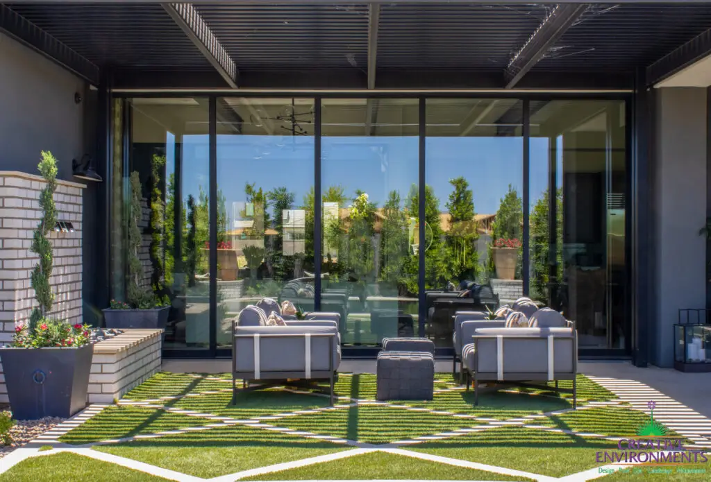 Custom backyard design with artificial turf pattern, topiaries and metal scupper water feature.