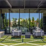 Custom backyard design with artificial turf pattern, topiaries and metal scupper water feature.