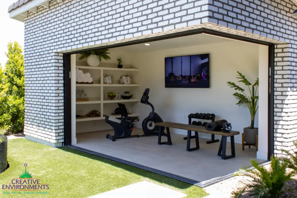 Custom backyard design with private gym, privacy hedges and artificial turf.