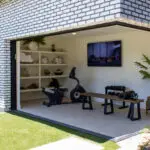 Custom backyard design with private gym, privacy hedges and artificial turf.