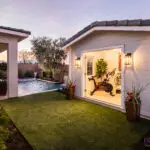 Custom backyard design with outdoor gym, pool and large metal planters.