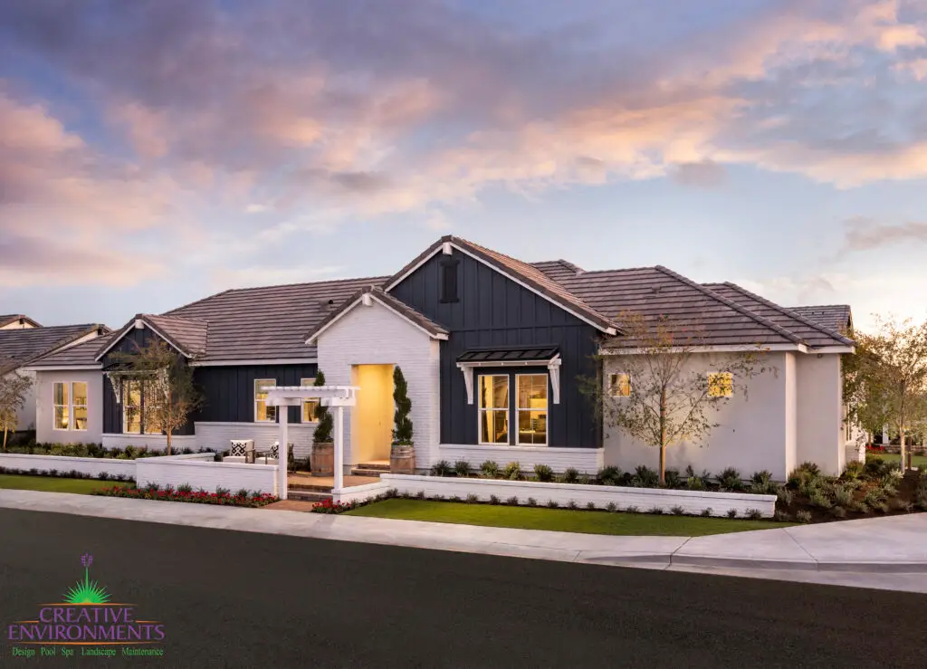 Custom front yard design with white wall, archway and artificial turf.