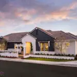 Custom front yard design with white wall, archway and artificial turf.