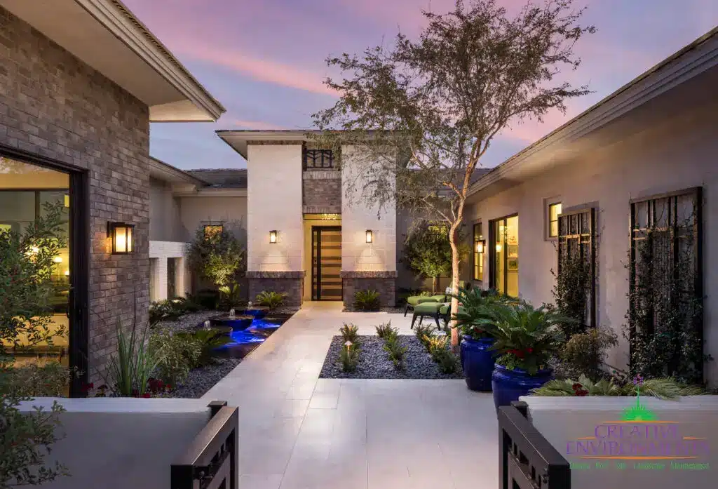 Custom front yard design with uplighting, metal trellis and water bubbler water feature.