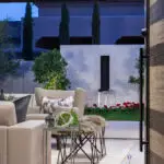 Custom backyard design with metal scupper water feature, up lighting and outdoor seating area.