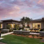 Custom front yard design with fire feature, up lighting and organized planting.