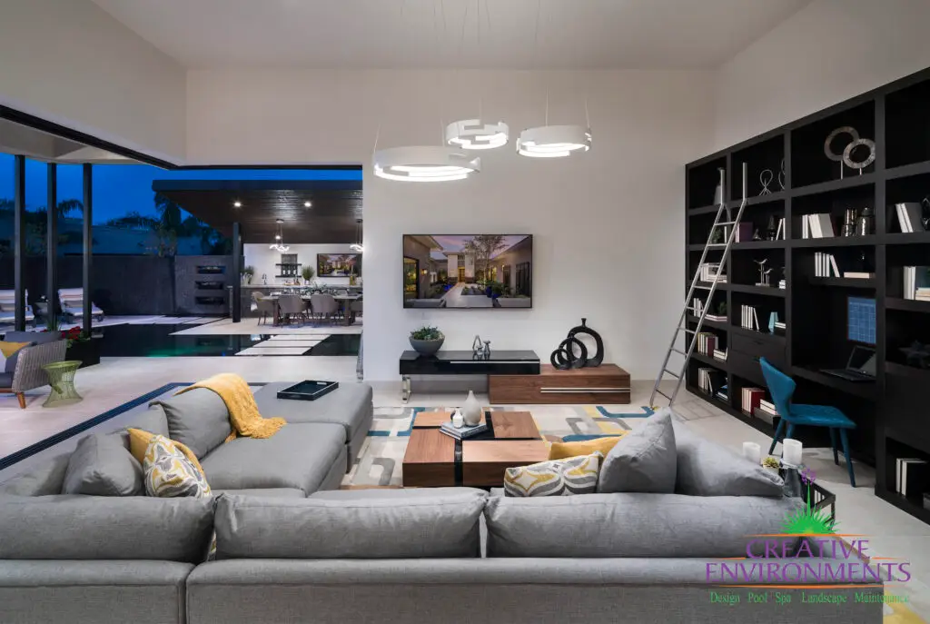 Custom indoor/outdoor design fusion with angled shade structure, outdoor dining area, Jesus steps and zero-edge pool.