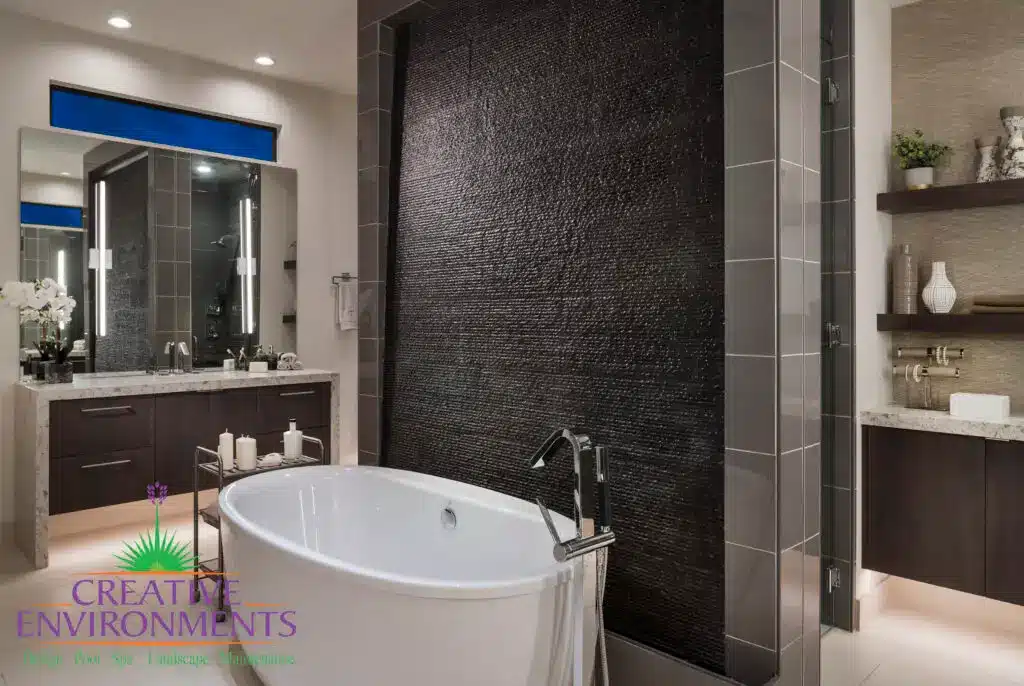 Custom backyard design with black water wall, outdoor tub and indoor/outdoor design fusion.