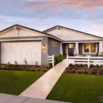Custom front yard design with organized planting, artificial turf and natural stone tile pathway.