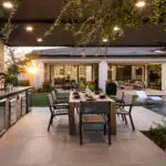 Custom backyard design with outdoor kitchen, pool with baja step and multiple seating areas.